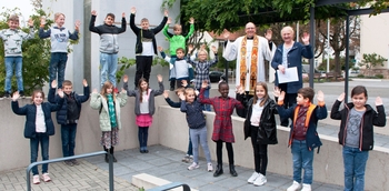  Das Foto zeigt einen Teil der Kesselstädter Kommunionkinder am Turm der St. Elisabeth-Kirche unter freiem Himmel. Für das Foto wurden die Mund-Nasen-Bedeckungen kurz abgelegt.